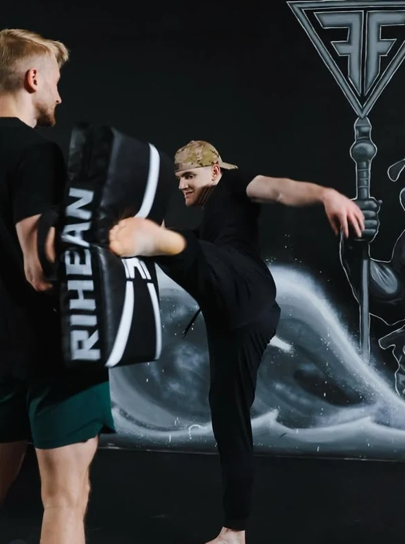 A Fuel Fortress combat class member practices a kick against a training pad