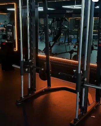 Cable training station with mirrored walls and warm lighting